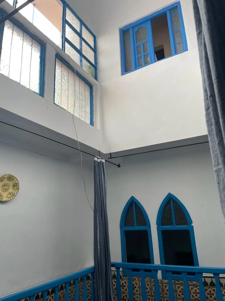 Patio du Riad Bleu Azahraa, murs blancs et menuiseries bleues.