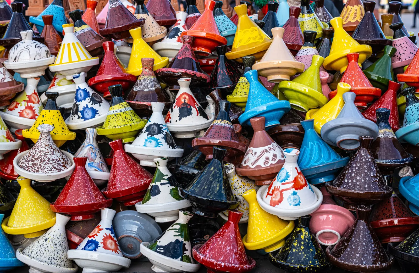 Des centaines de couvercles de tajines émaillés de toutes les couleurs, entassés sur un étal.